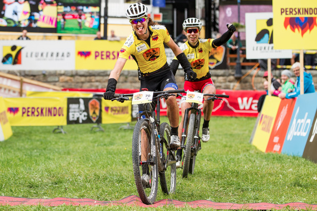 Ariane Kleinhans s Annikou Langvad protíná vítězně cílovou pásku 1. etapy Swiss Epic